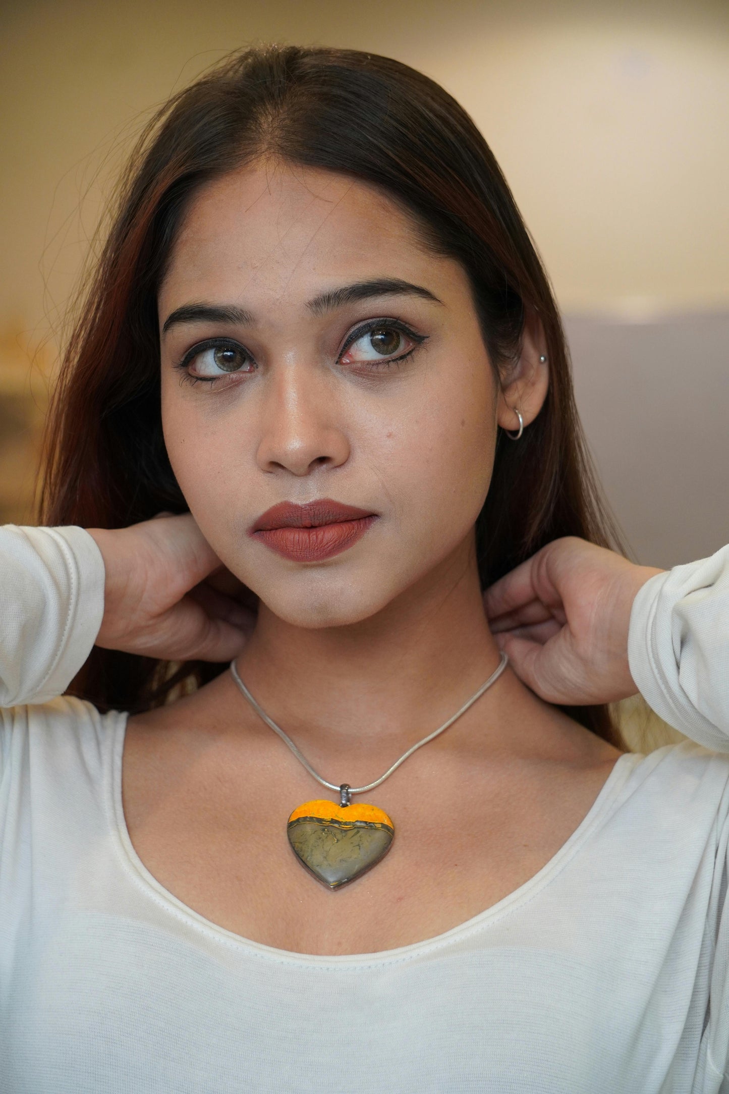 young woman applying a Numina heart shaped necklace